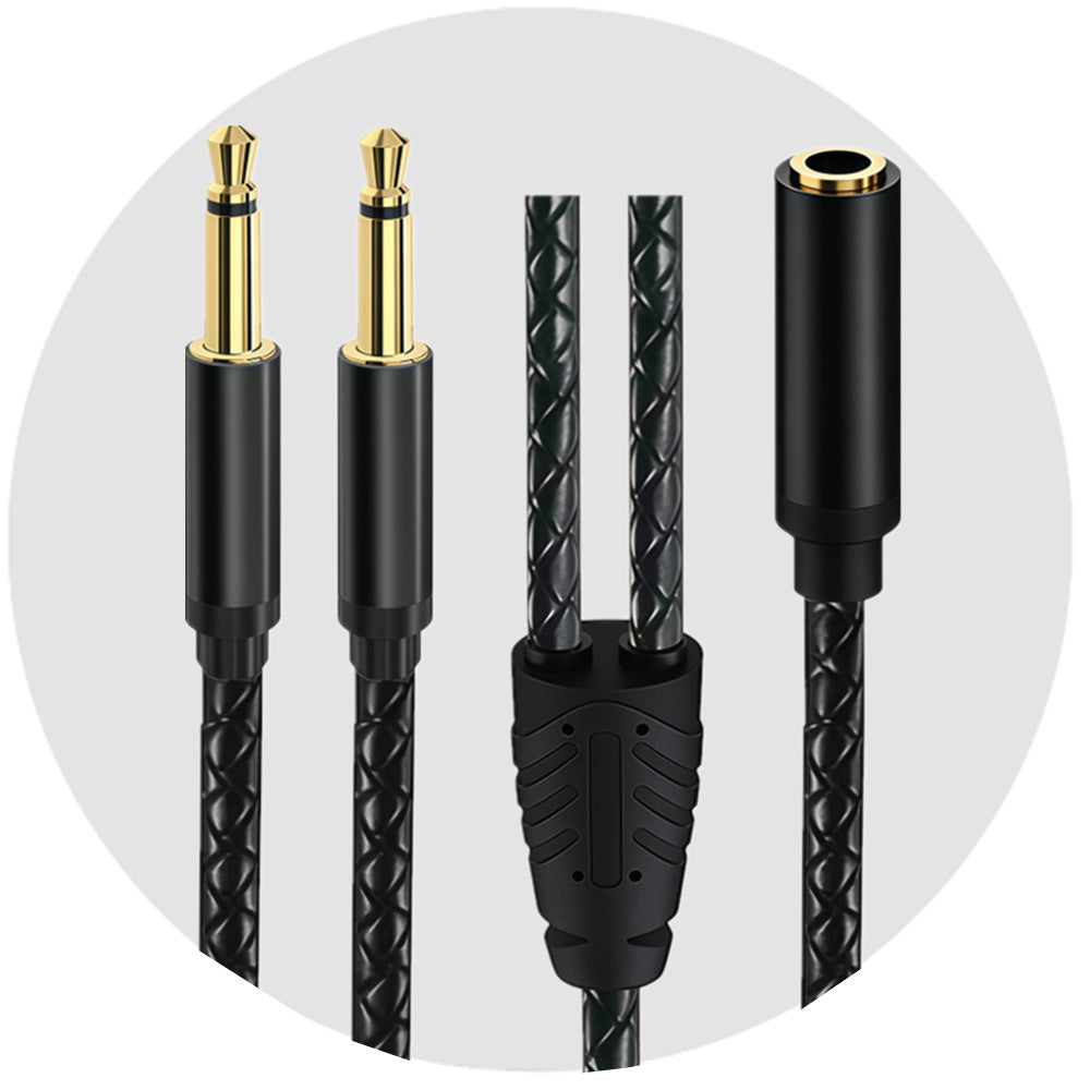 female socket, two mono male plugs and braided Y junction of a black 3.5mm audio cable against a grey circular background