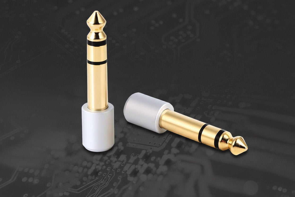 Two audio connectors, one gold and one white, on a dark background with circuit board details.