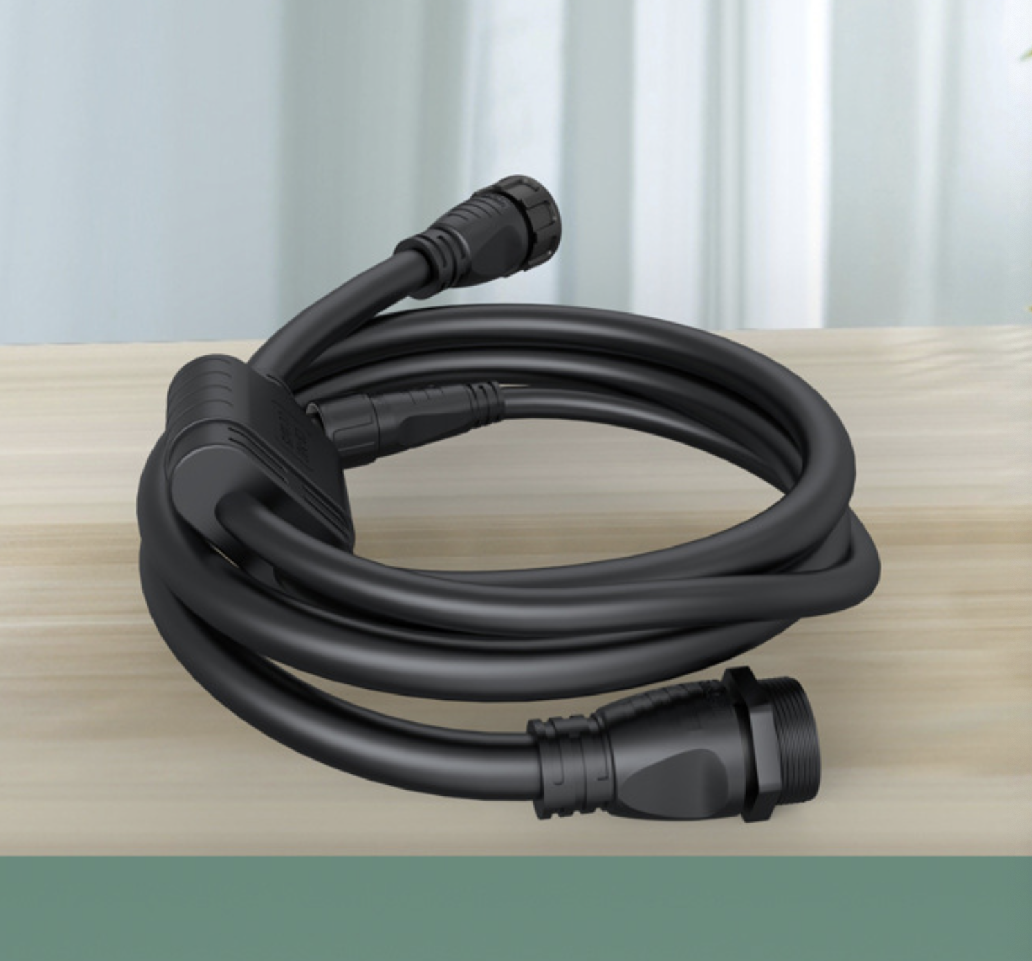 Coiled black cable with connectors on a wooden surface