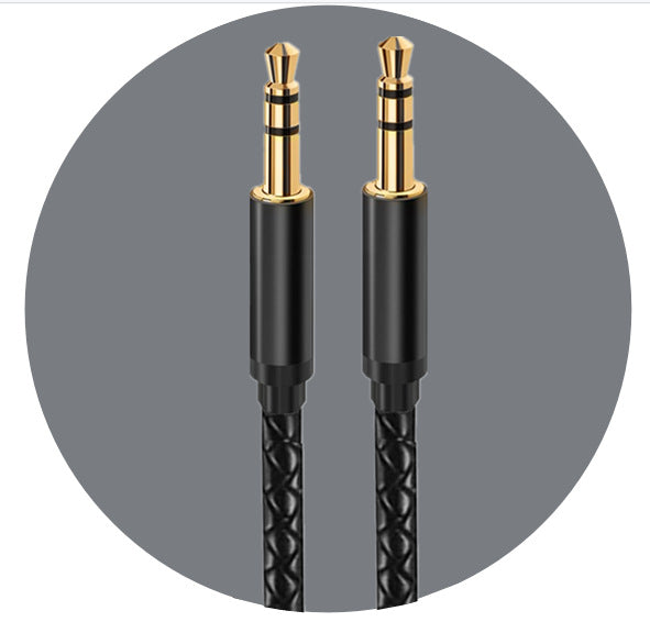 Two gold-plated 3.5mm stereo jack plugs with black housings against a grey background