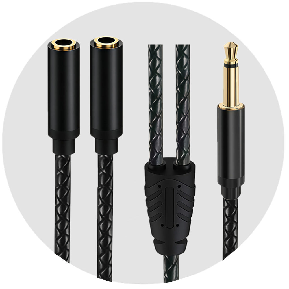 Two female sockets and one straight mono male plug on a black braided Y audio cable against a light grey circular background