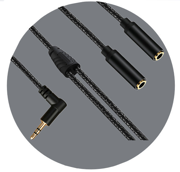 Diagonal view of the connectors and moulded junction of a black braided Y audio cable against a grey circle