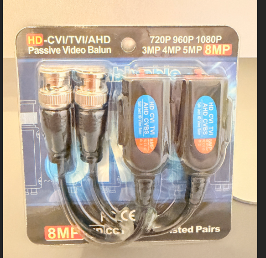 A retail-packaged set of two black passive video baluns with BNC connectors, labeled 'HD-CVI/TVI/VVI/AHD' and '8MP', in blister packaging.