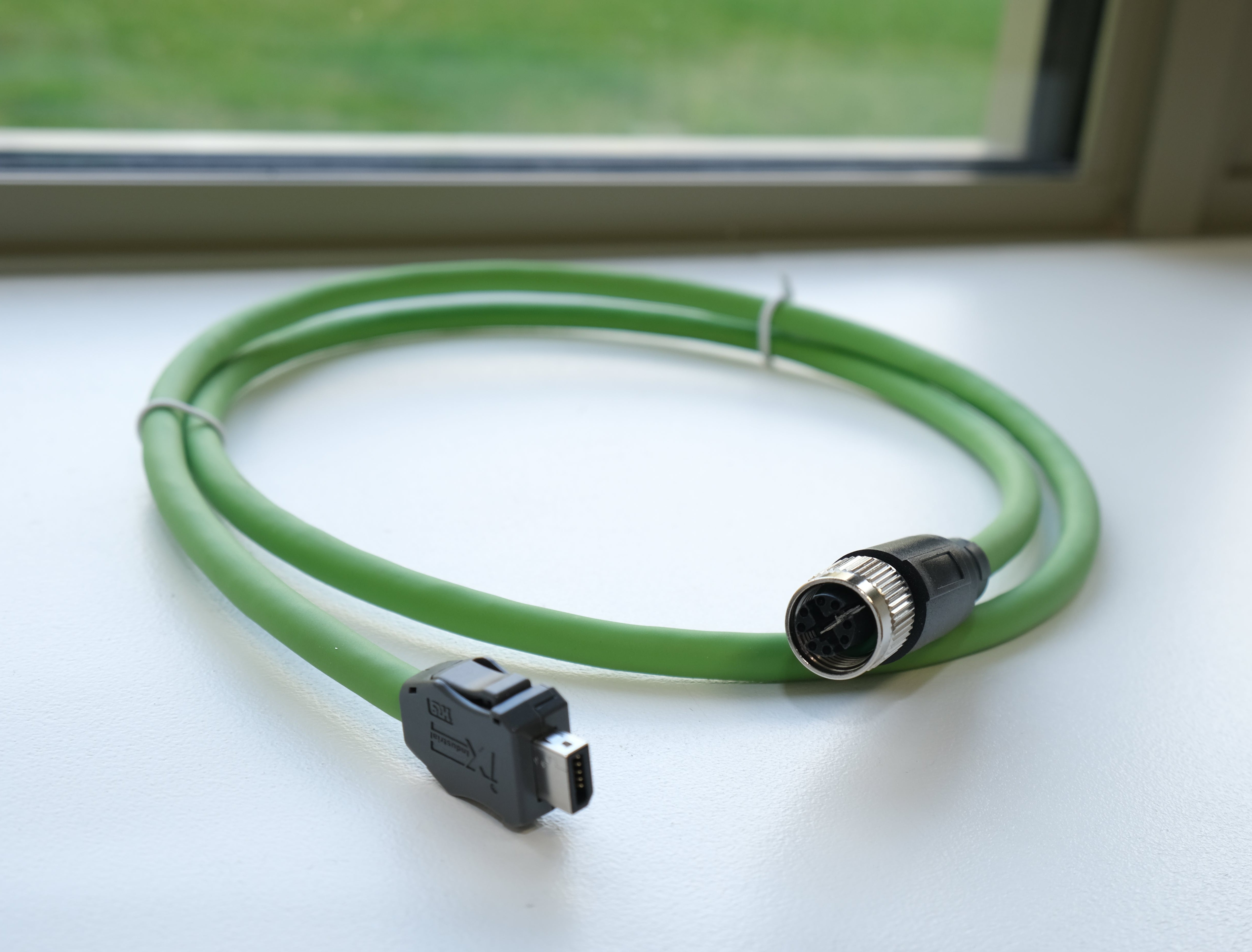 Green cable with connectors on a white surface