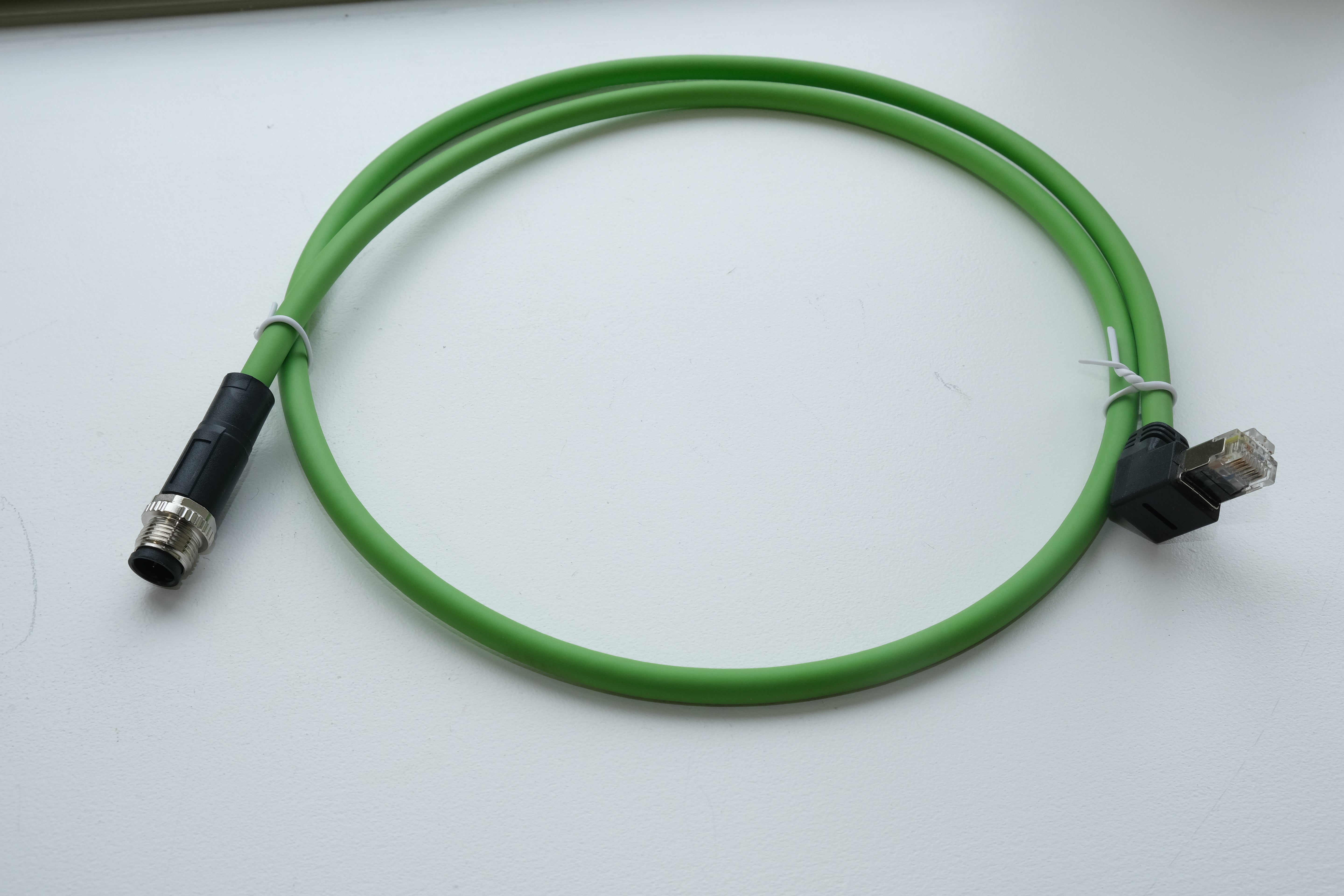 Green cable with one end in black connector on a white background