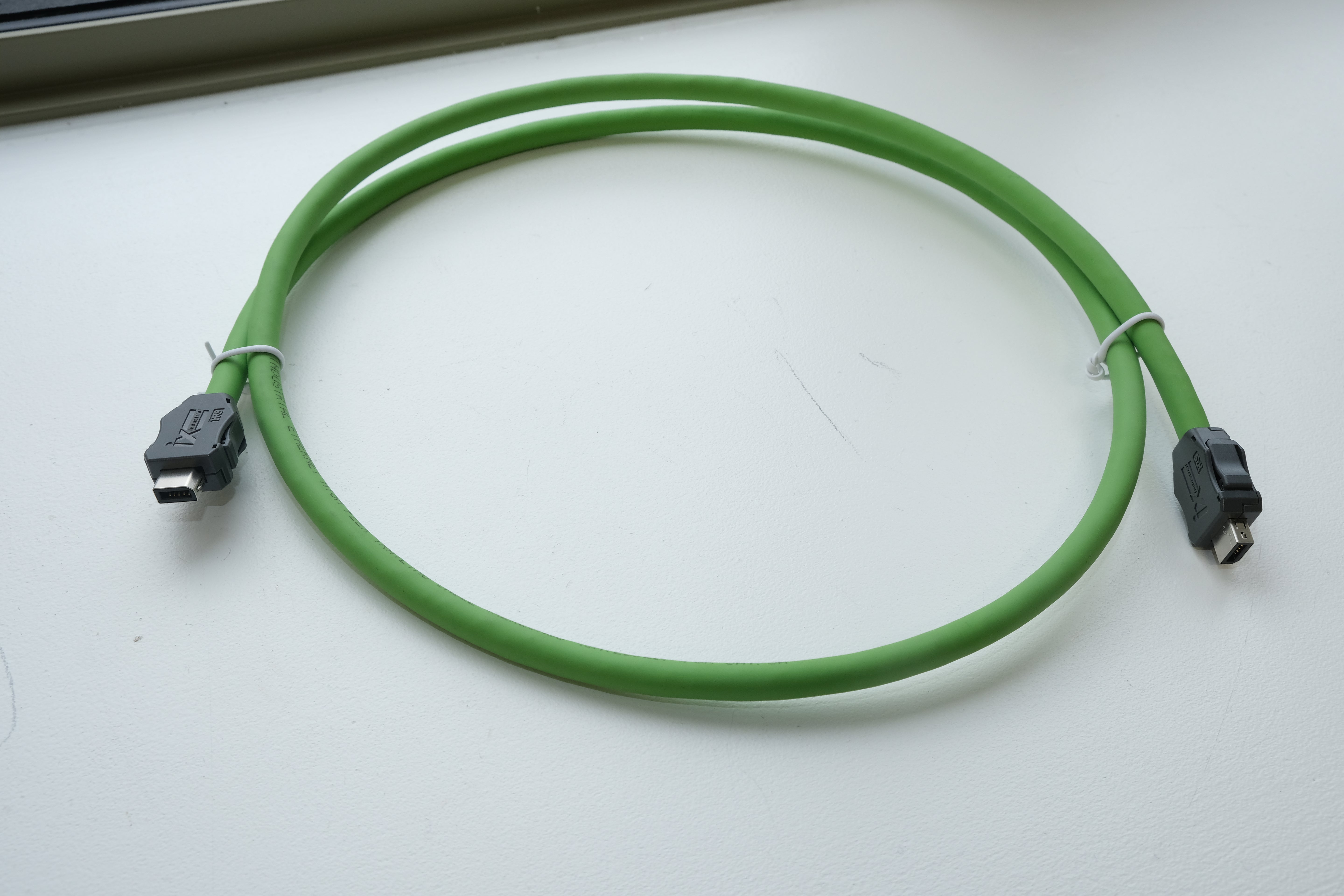 Green USB cable coiled on a white surface