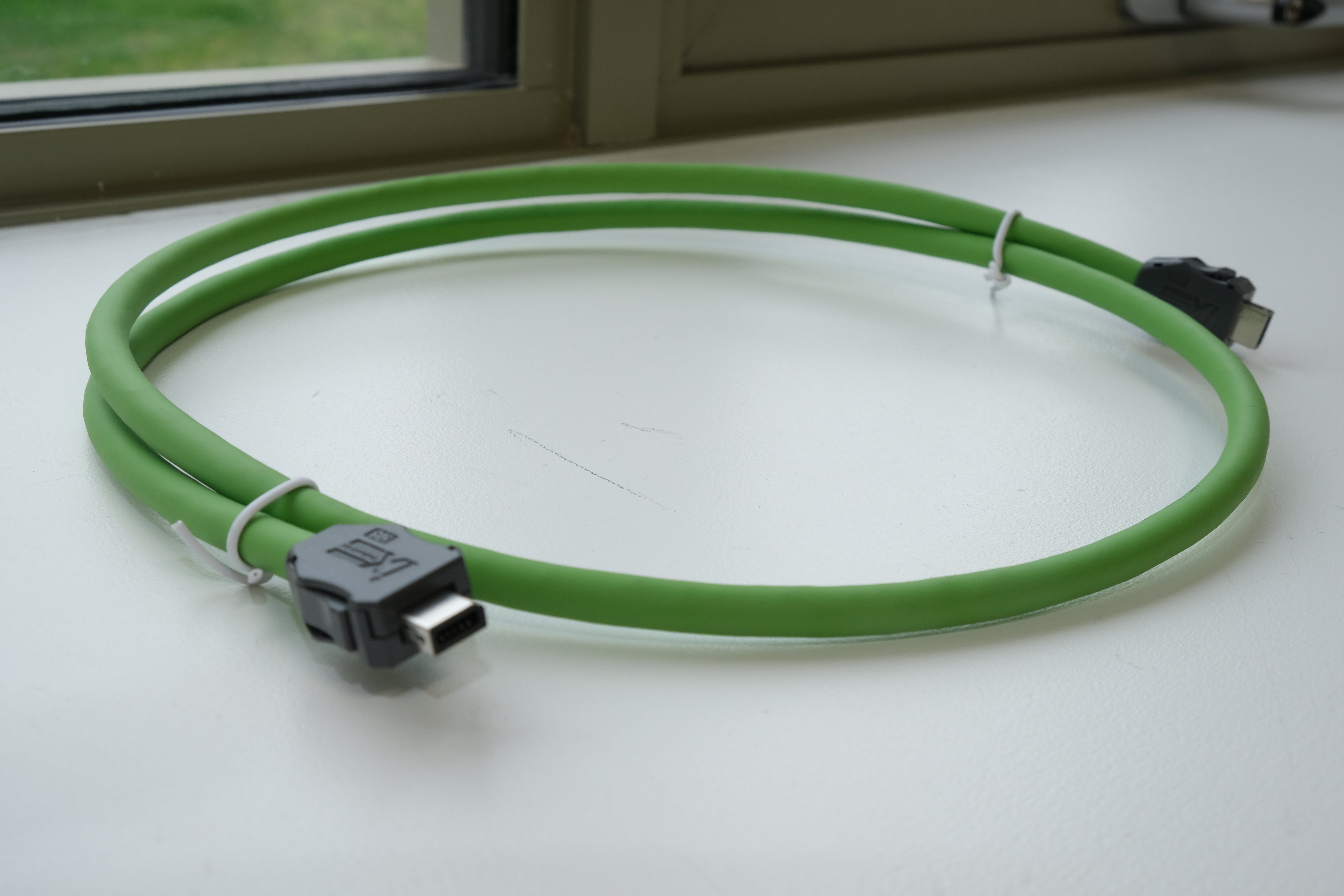 Green cable with USB connectors on a white surface