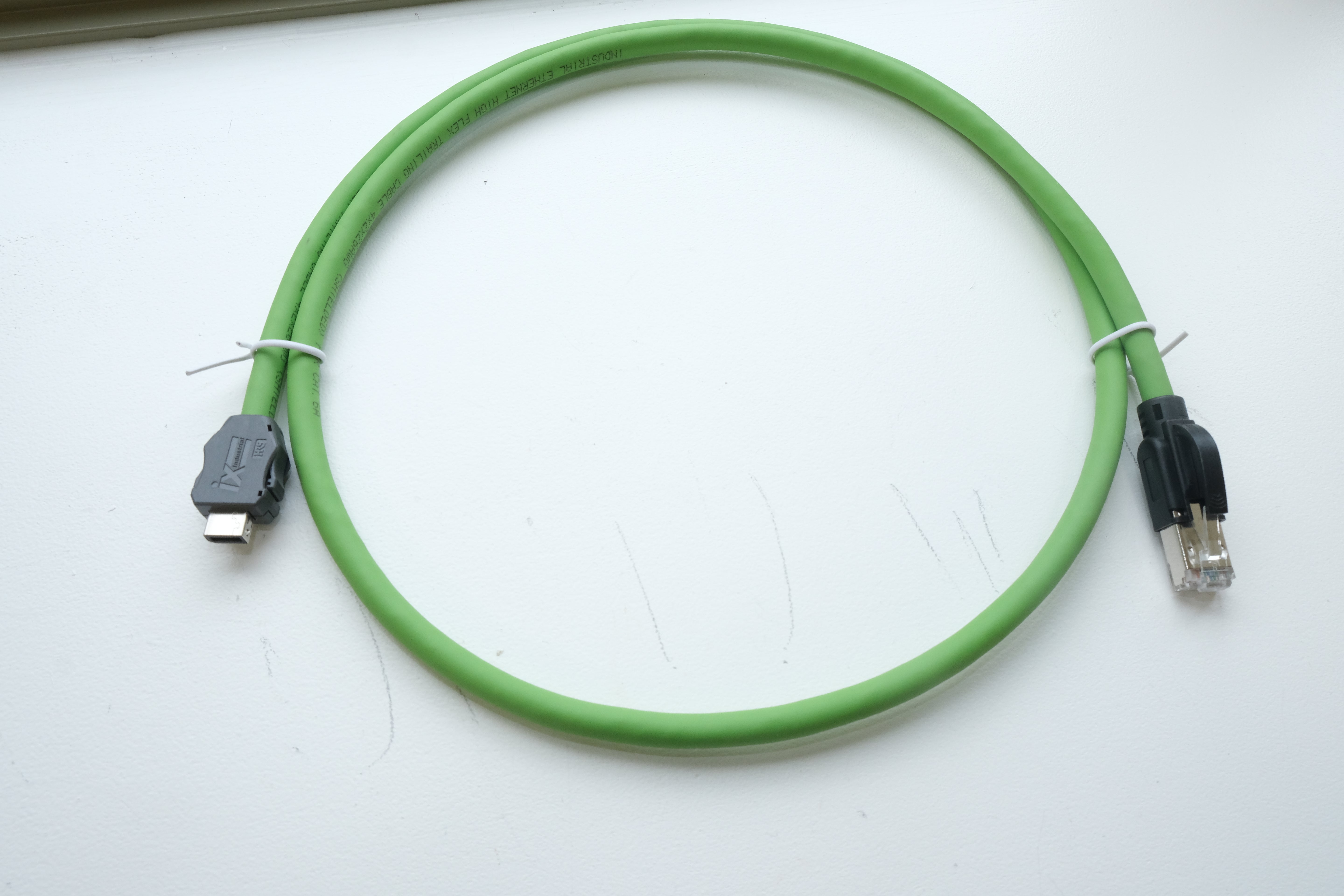 Green Ethernet cable with connectors on a white background