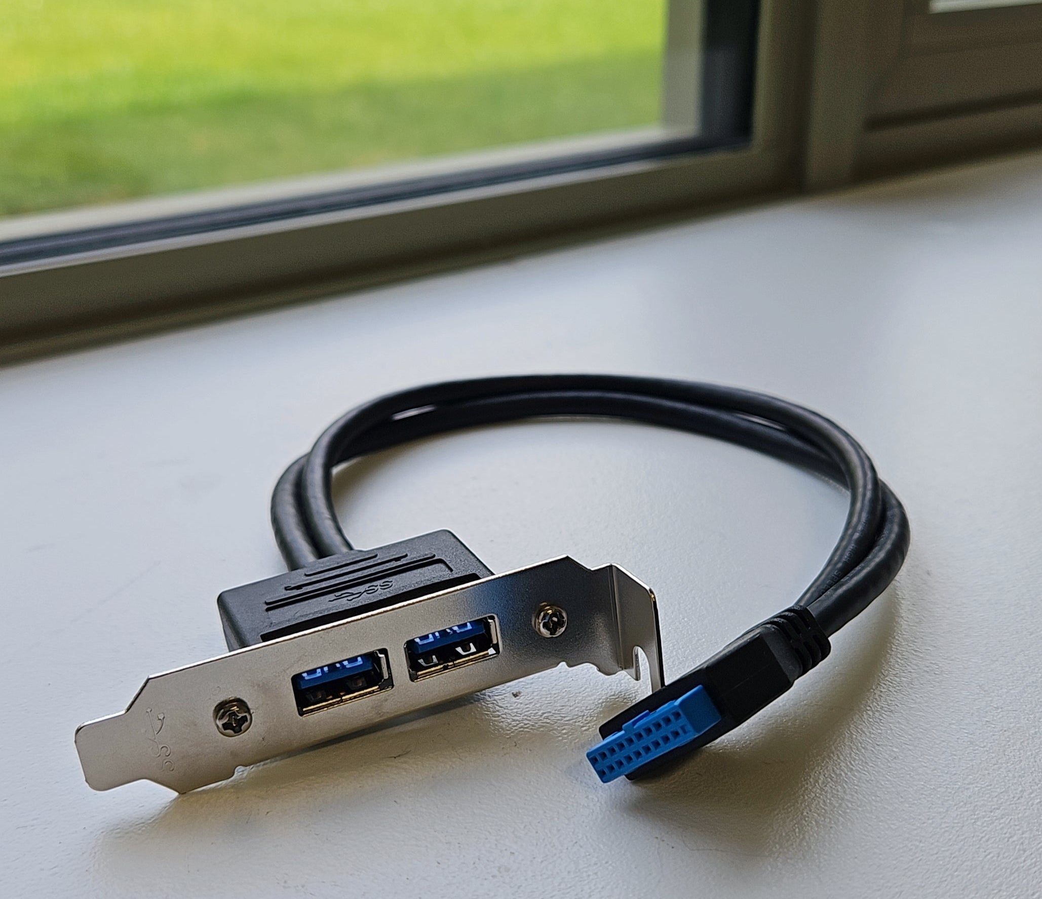 USB adapter cable on a surface with a window in the background