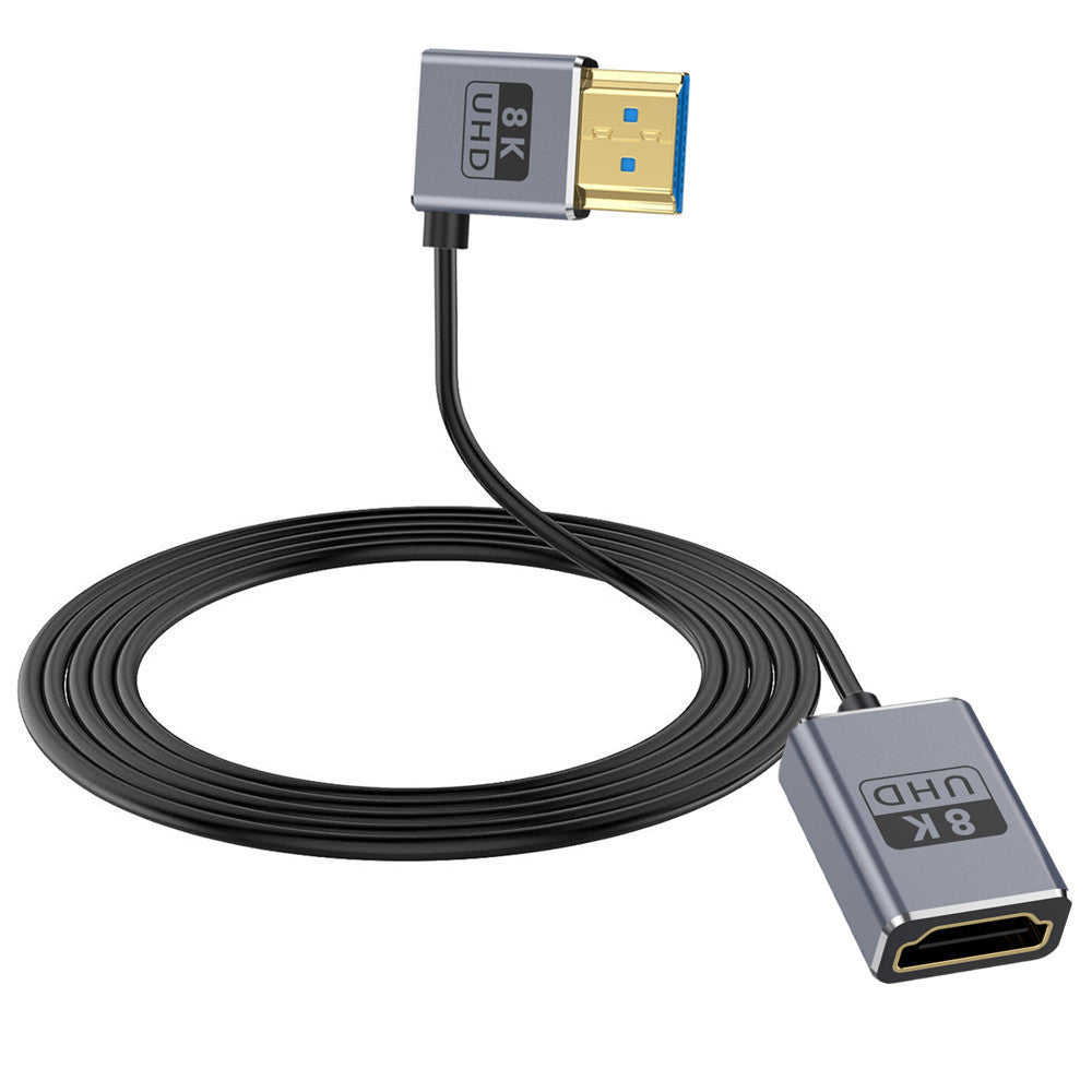 An ultra thin HDMI 2.1 coaxial extension cable with a left angle connector, featuring a gray male HDMI connector on one end and a black female coaxial connector on the other, with a black flexible cord in between.