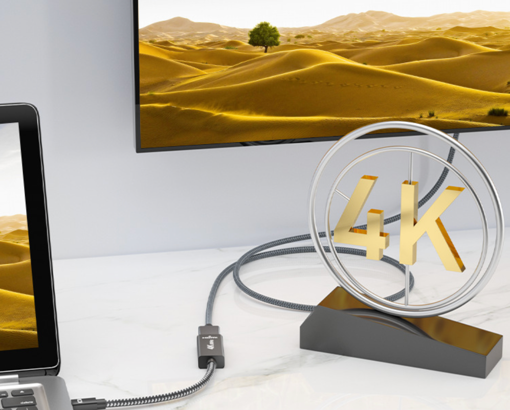 4K display with laptop and decorative '4K' sign on a white surface