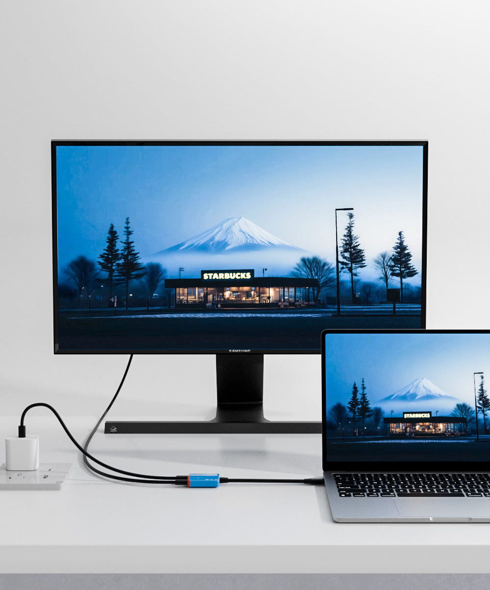 Monitor and laptop displaying a scenic wallpaper with a mountain and trees on a white background.