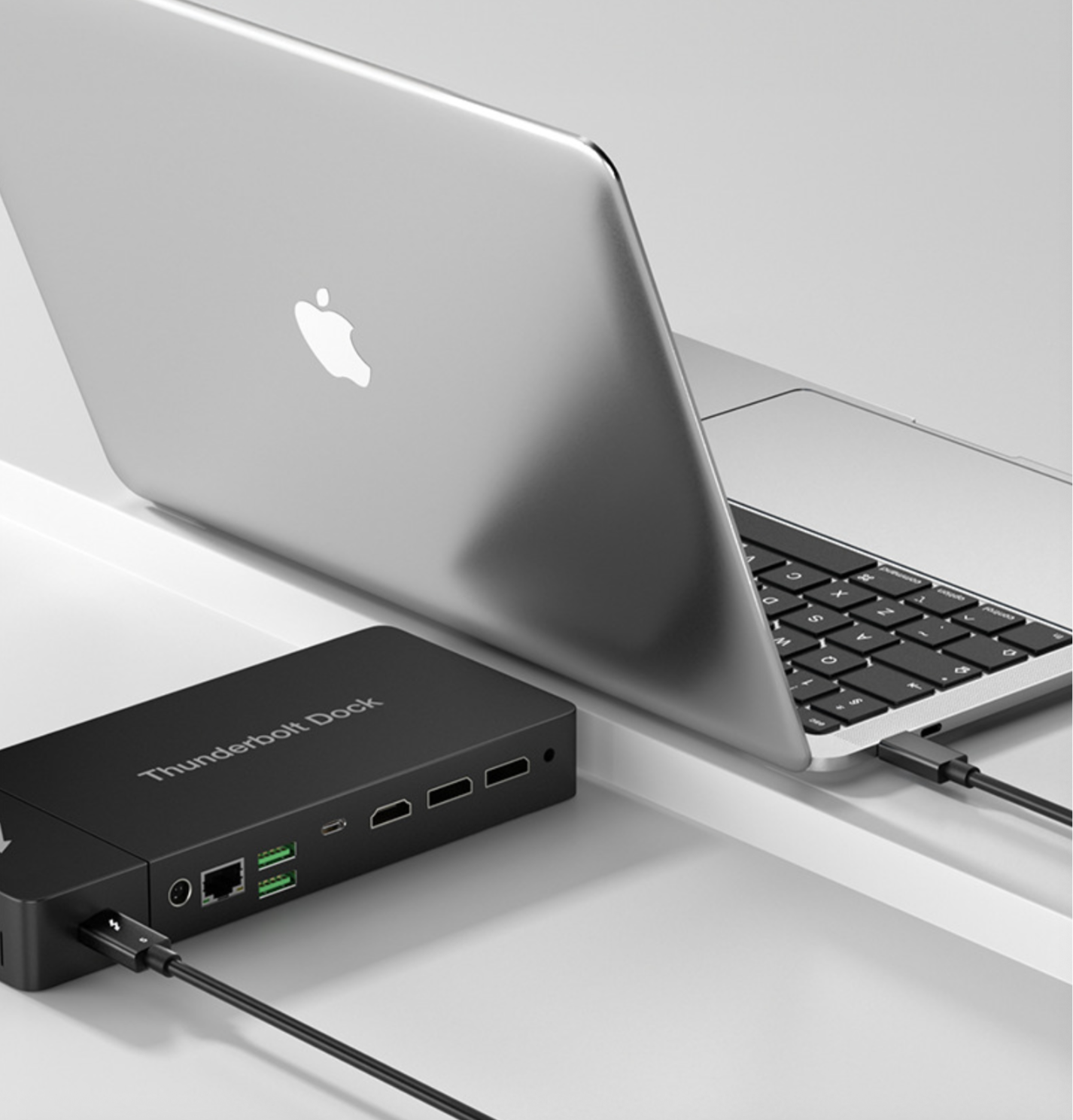 Laptop connected to a Thunderbolt dock on a white surface