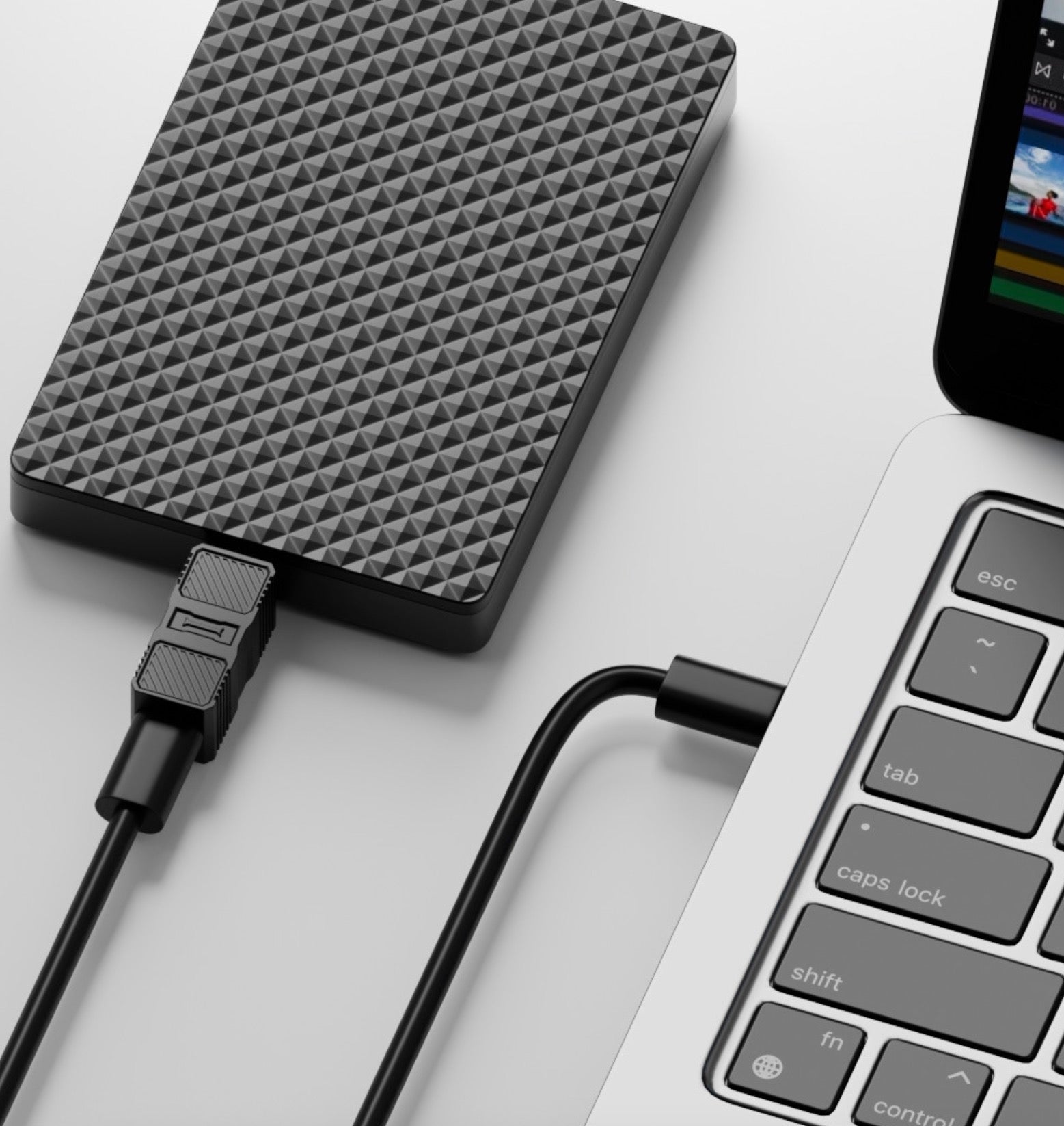 External hard drive connected to a laptop on a light background