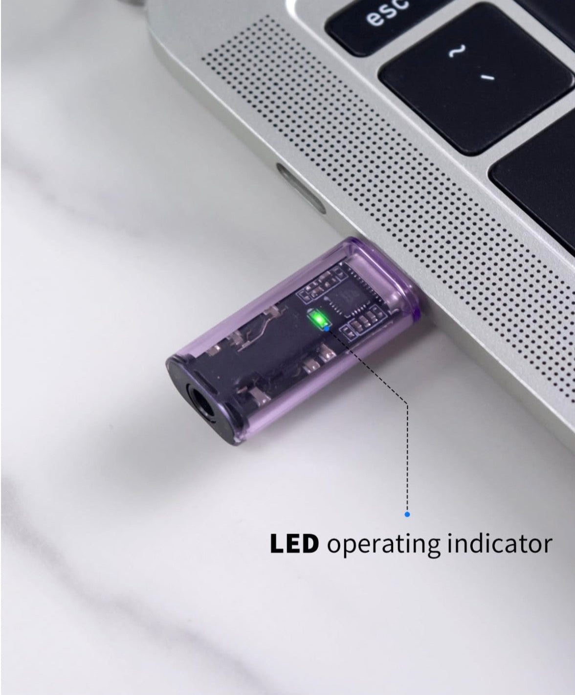 Purple USB device with LED indicator on a laptop