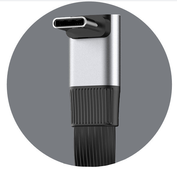 Close-up of a black and silver cylindrical device with a textured grip on a gray background