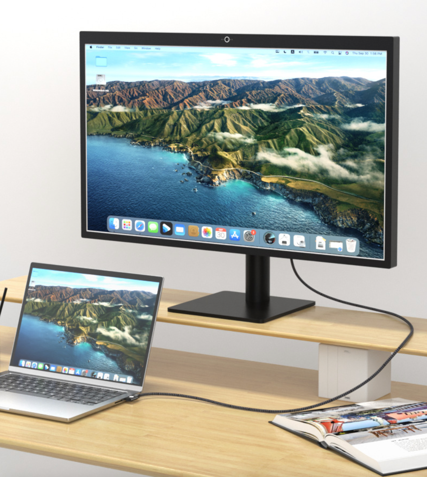Two computer monitors displaying a scenic wallpaper on a wooden desk.