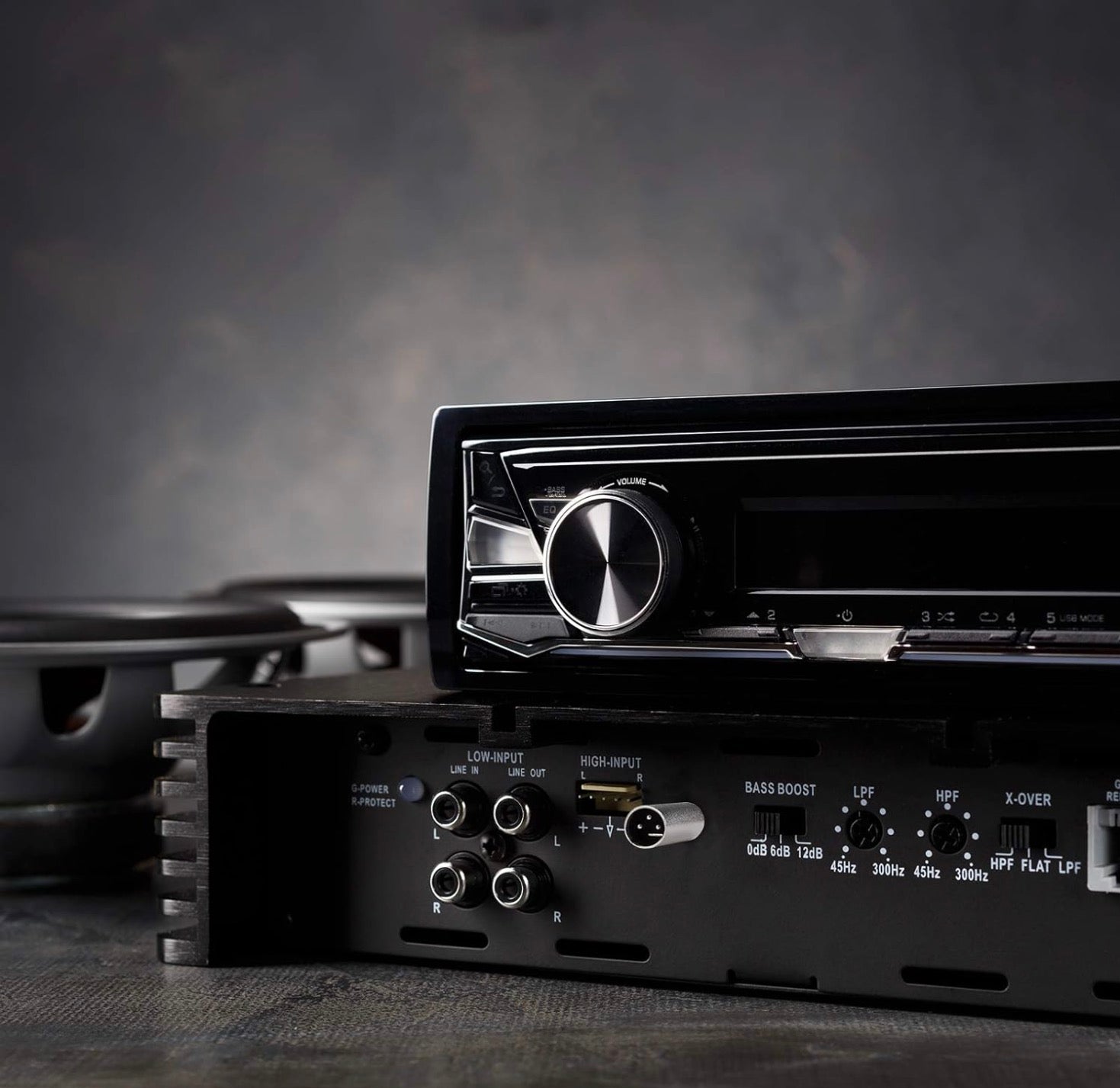 Close-up of a black audio amplifier with control knobs and ports.