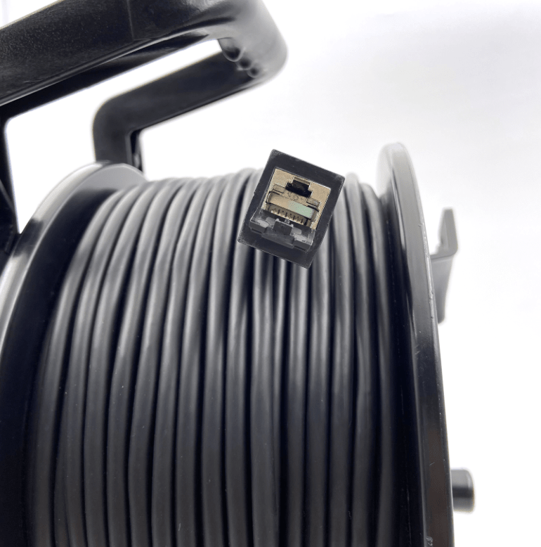 Close-up of RJ45 connector on CAT6A outdoor Ethernet cable reel.