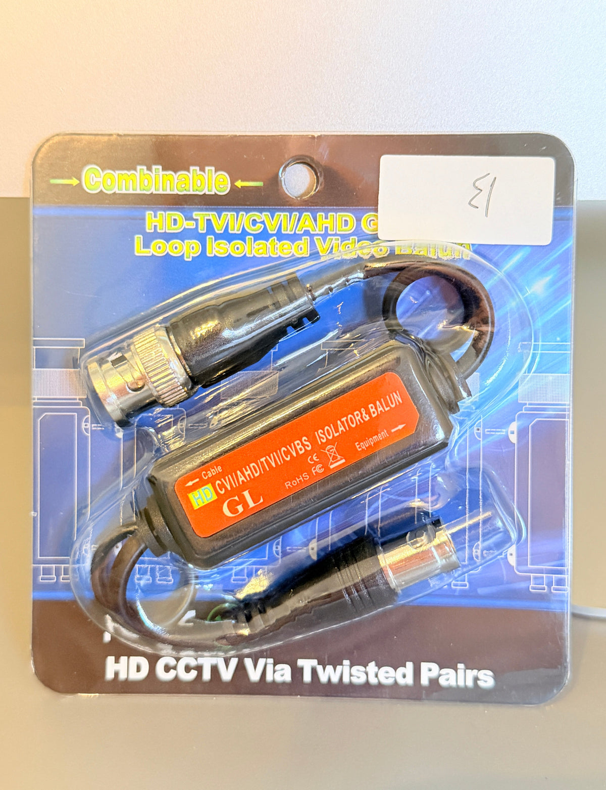 A GL Cybertronics CCTV via twisted pairs loop isolator in its original retail blister packaging, featuring a black and orange device with attached cables on a blue graphic backing card.