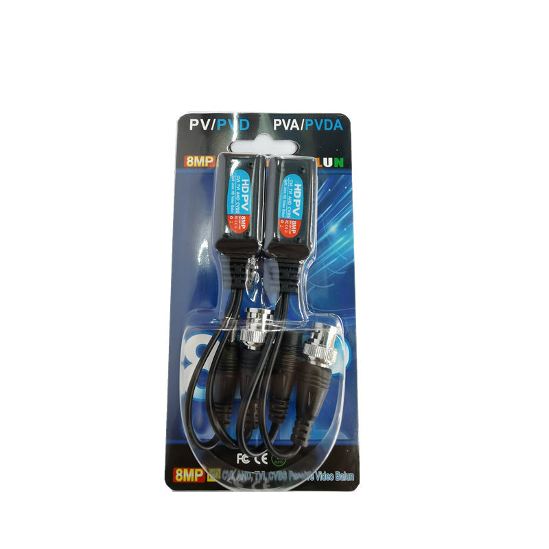 Two black automotive video loopback adapters with blue and orange indicator labels, packaged in a clear blister pack on a blue backing card.
