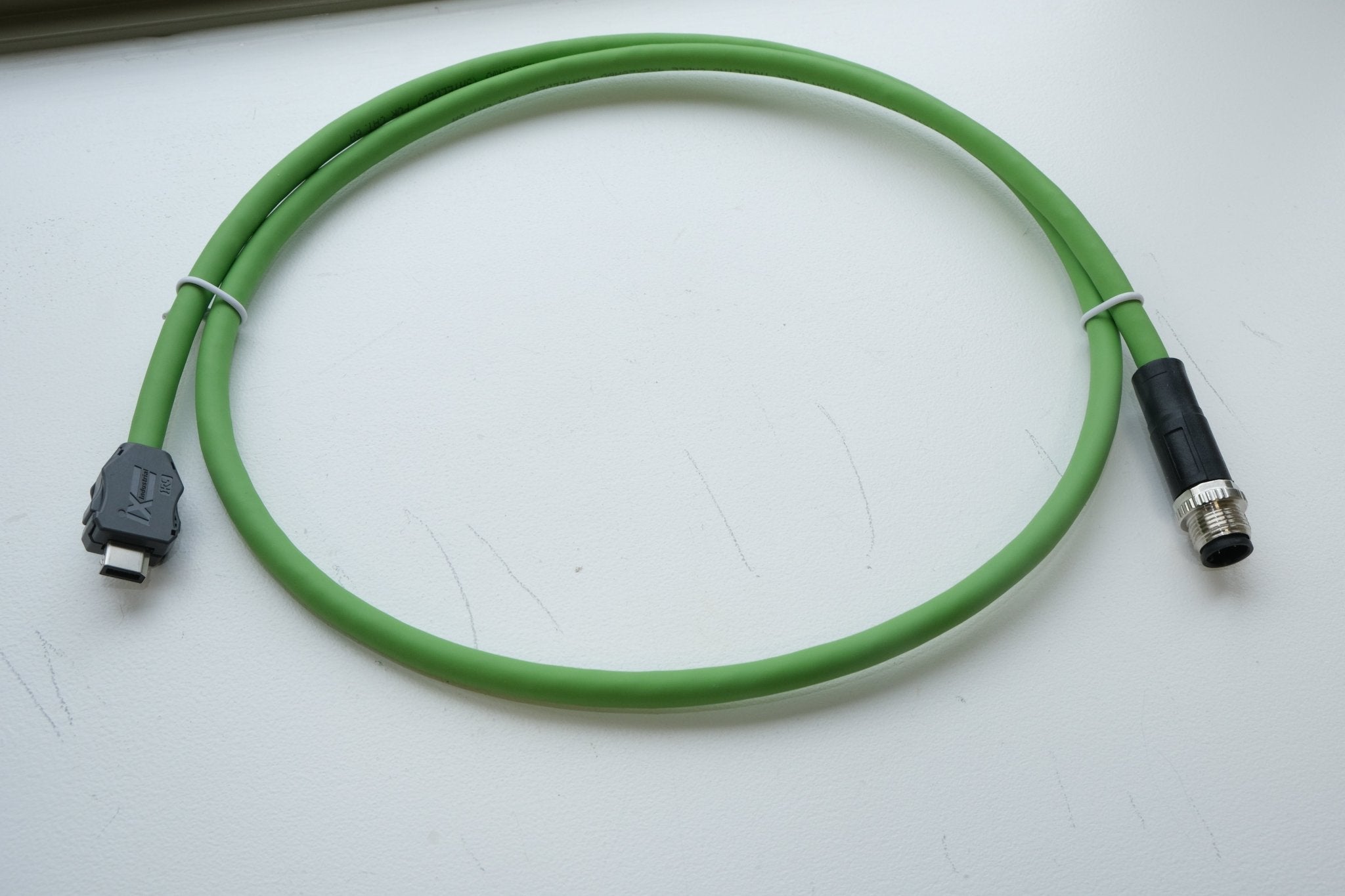 Green cable with connectors on a white surface