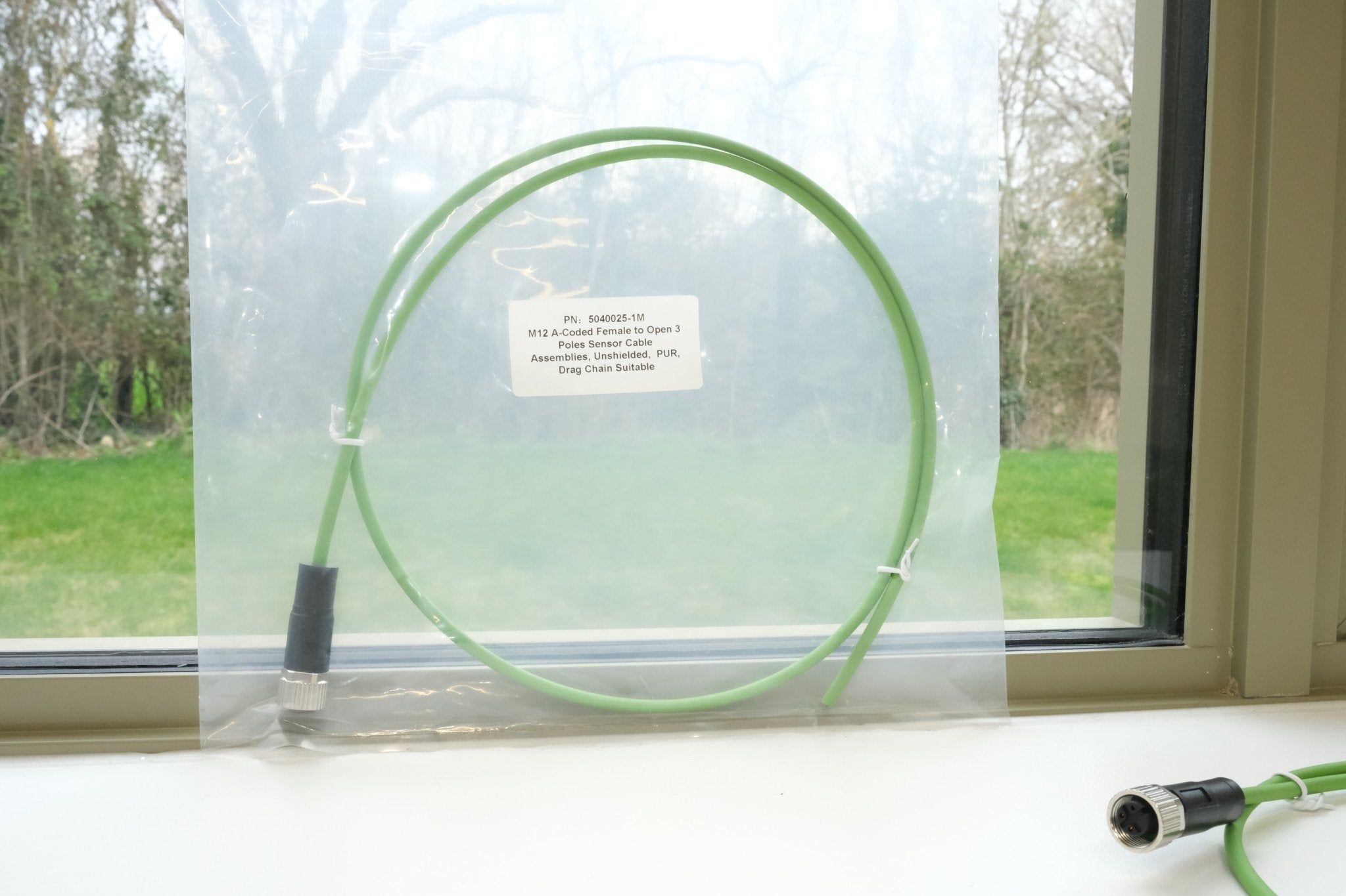 Green cable with label on a window