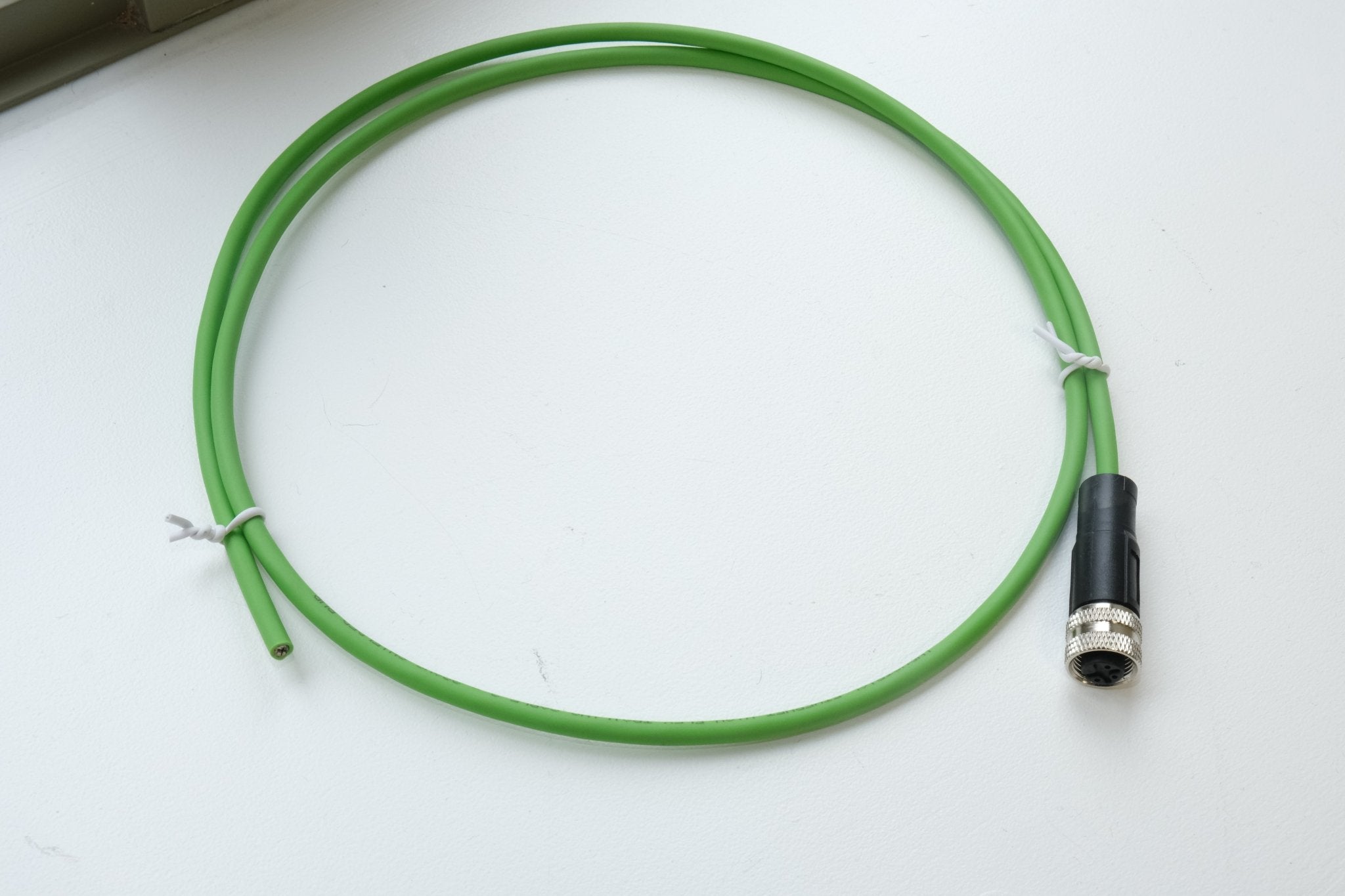 Green cable with a black connector on a white background