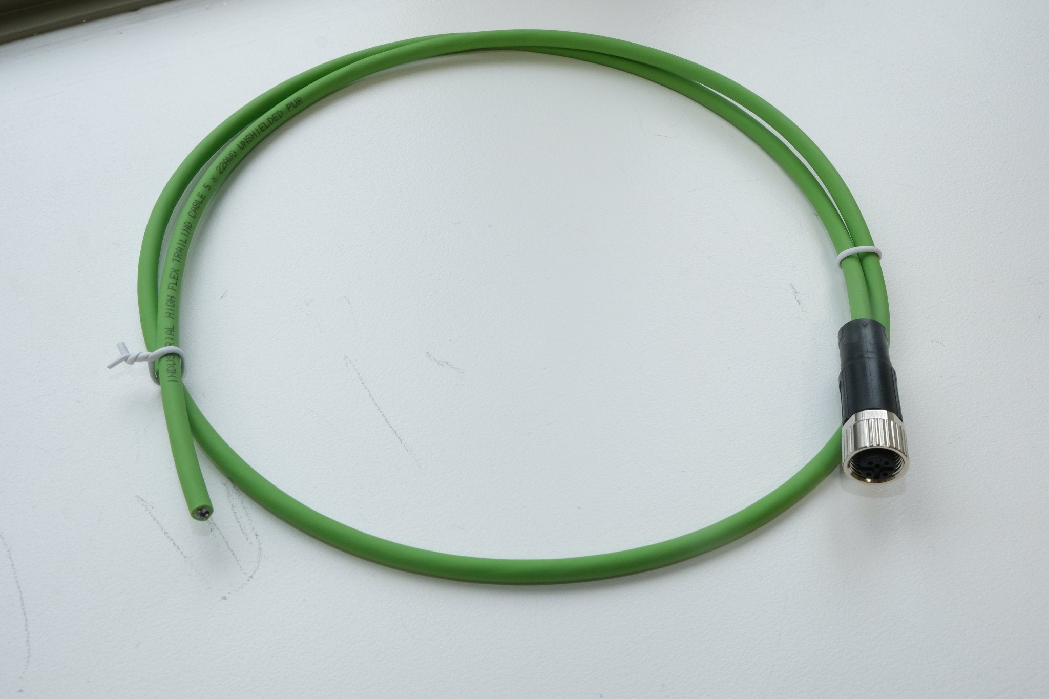 Green cable with a black connector on a white background