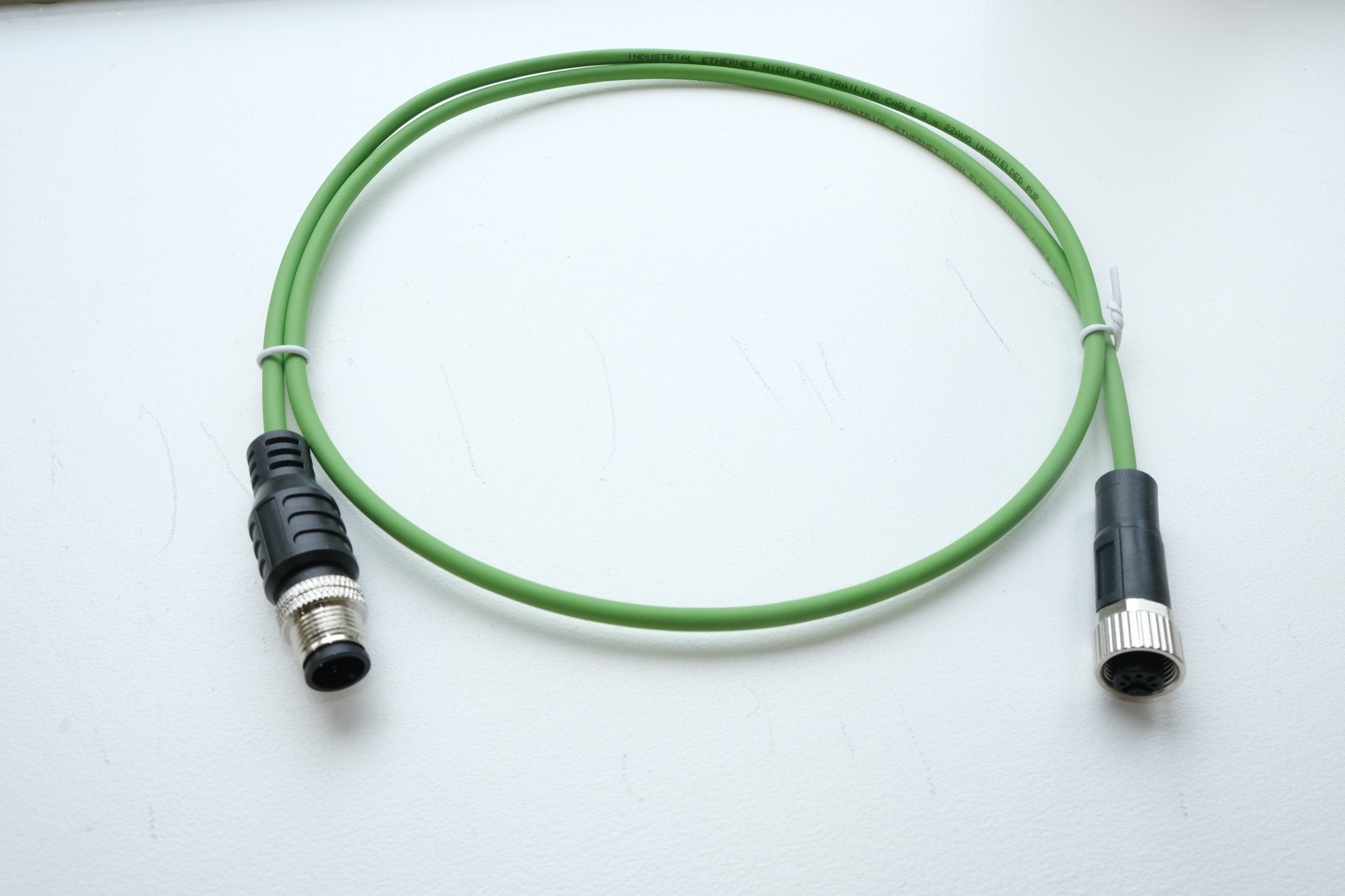 Green cable with black connectors on a white background