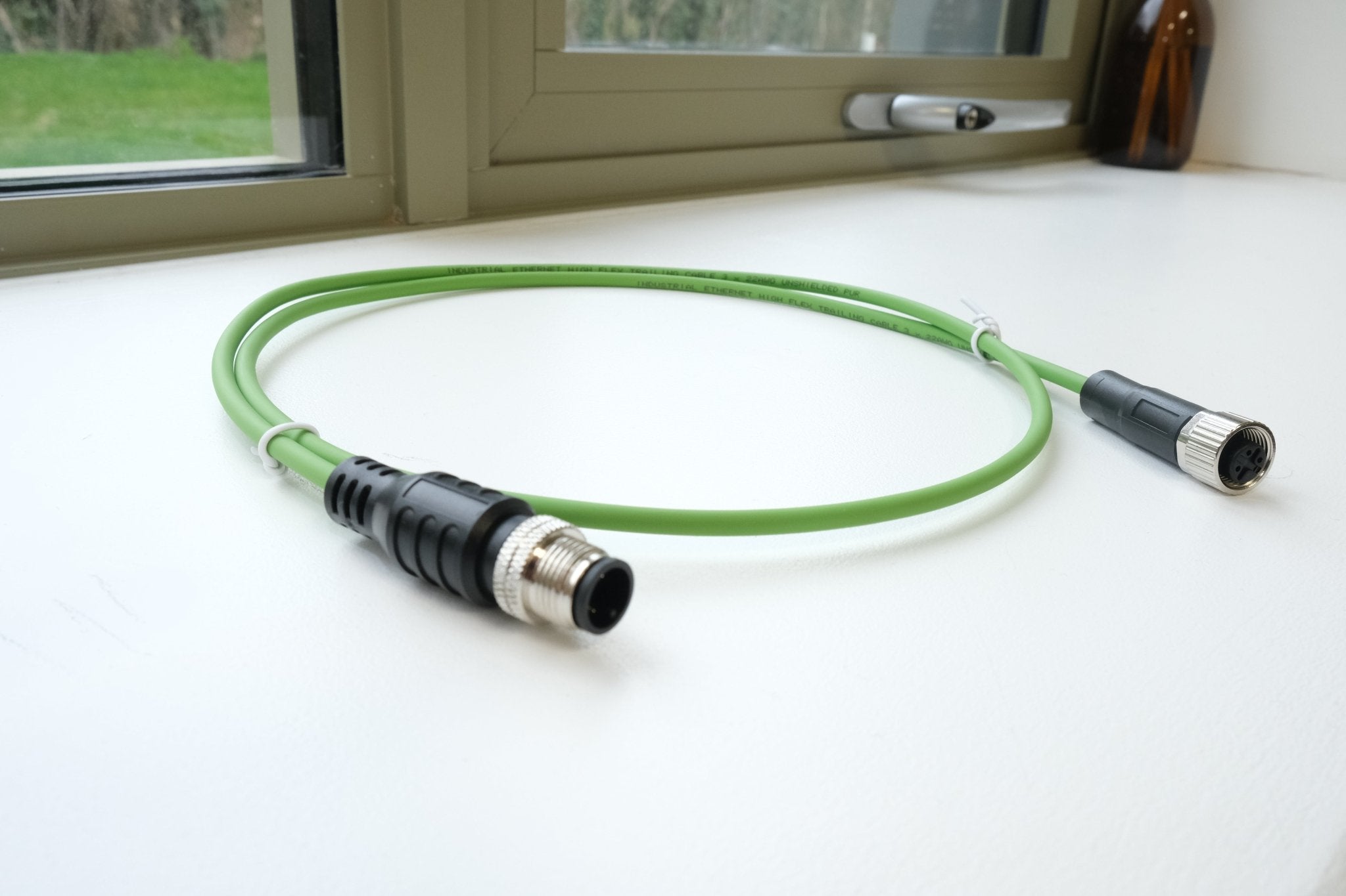 Green cable with connectors on a white surface
