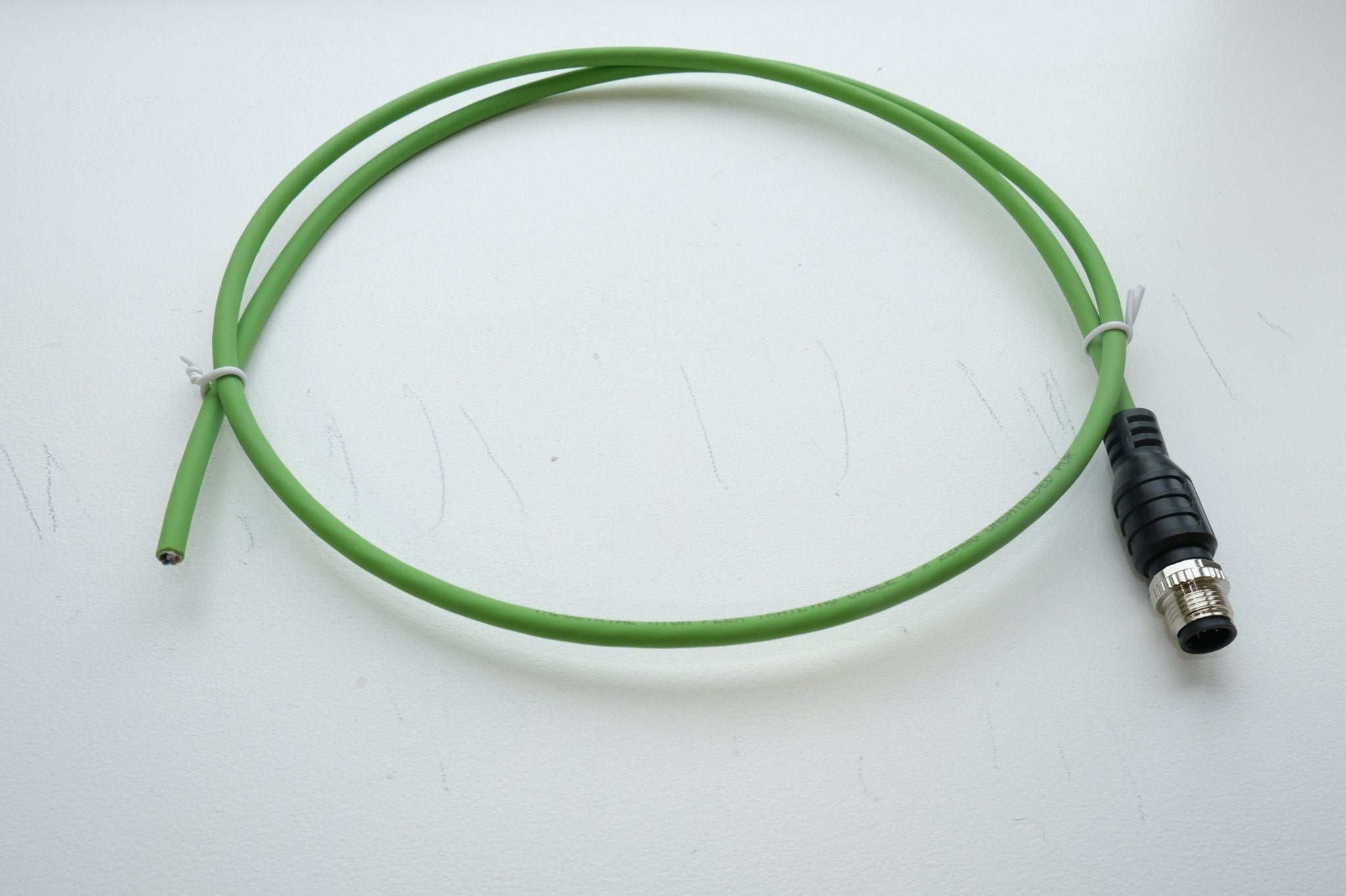 Green cable with a black connector on a white background