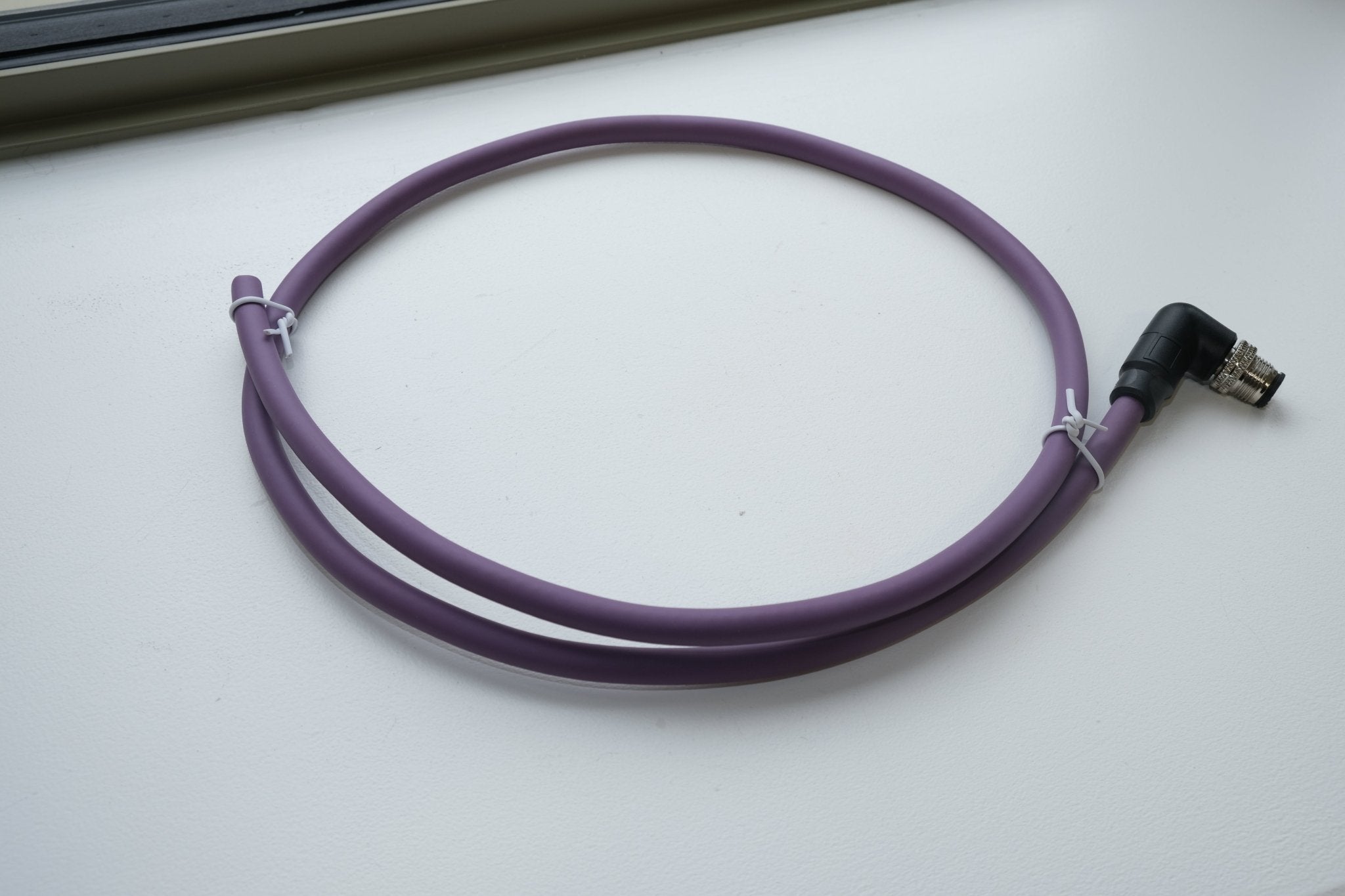 Purple USB cable with a 90-degree connector on a white surface