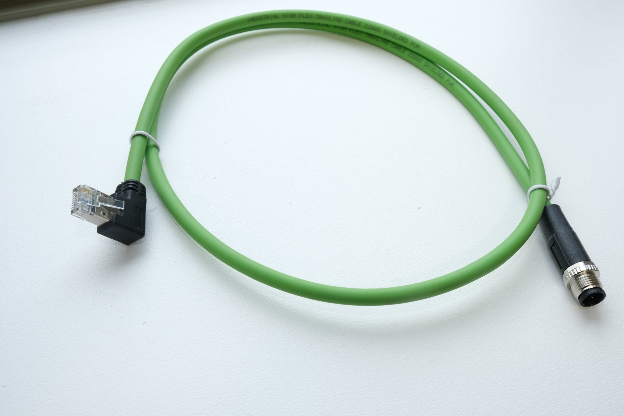 Green cable with electronic connectors on a white background