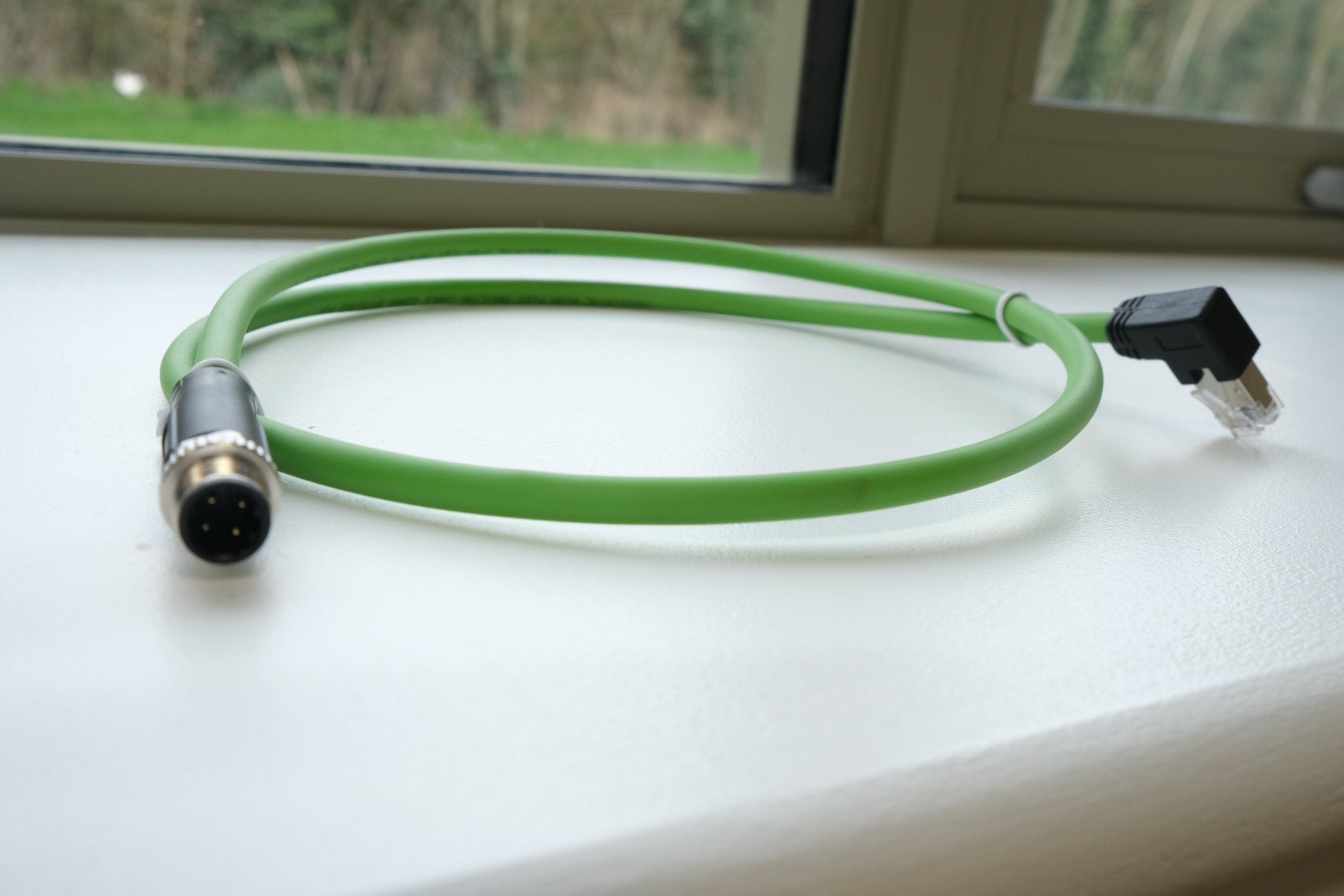 Green cable with connectors on a white surface