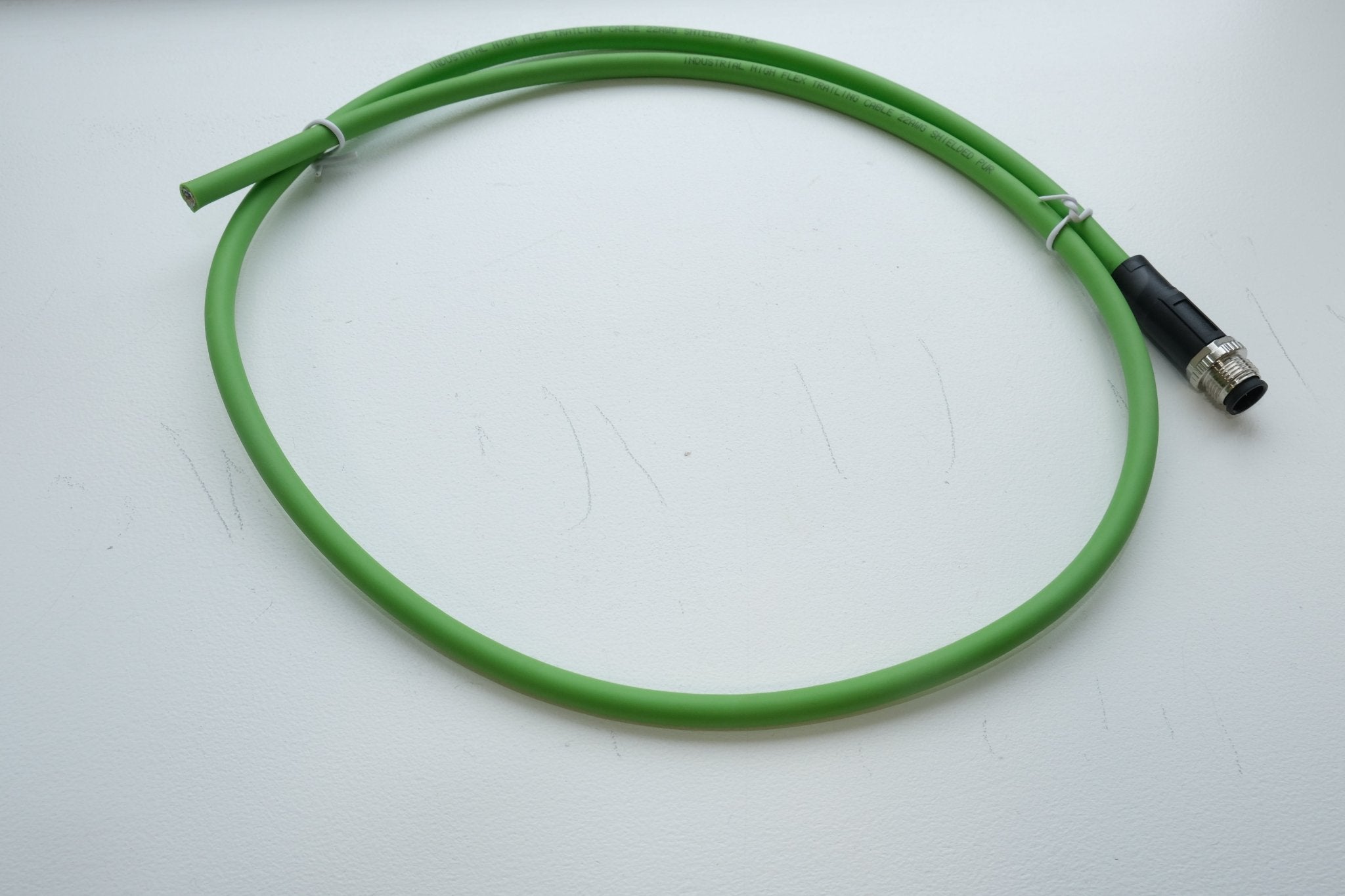 Green cable with a black connector on a white background