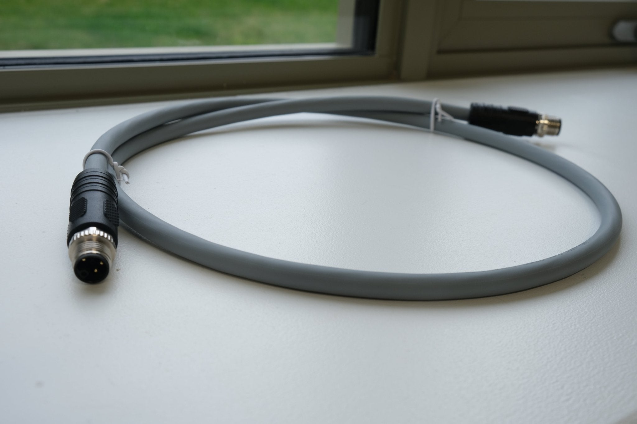 Gray cable with connectors on a reflective surface