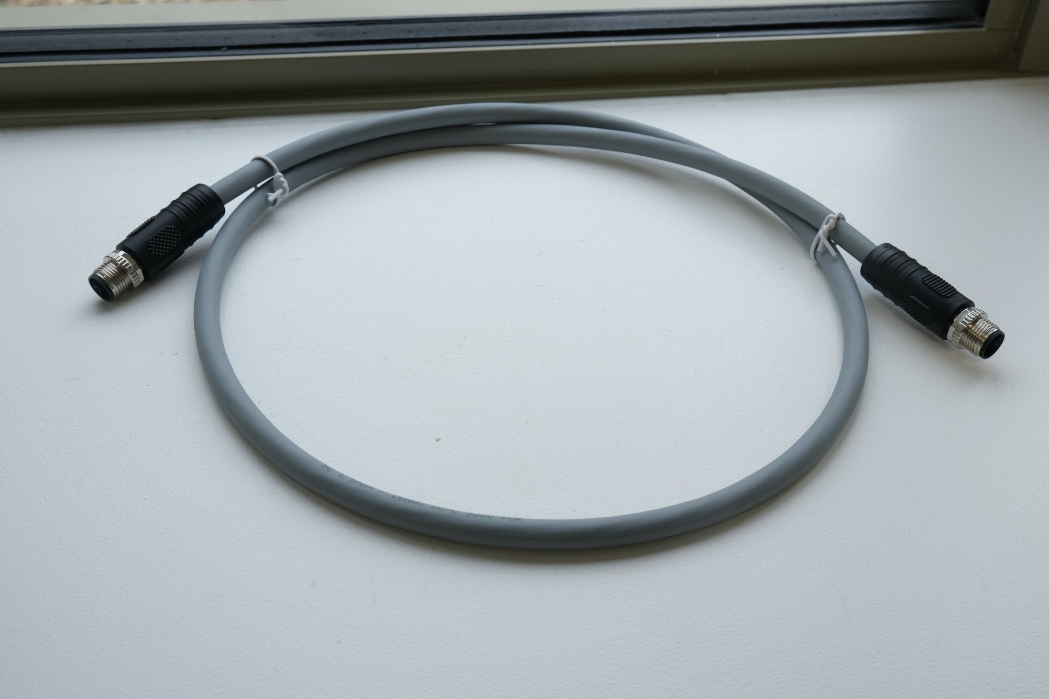 Coiled cable with connectors on a white surface