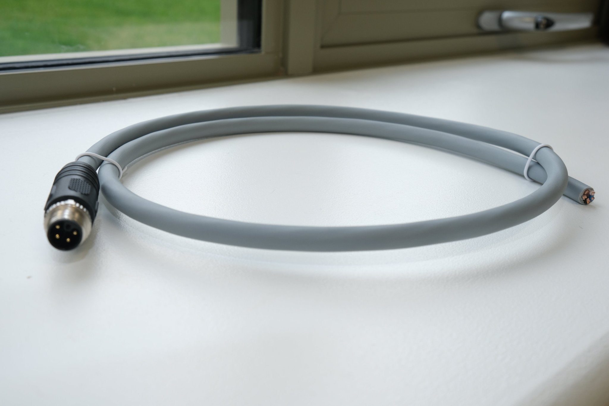 Gray cable with connectors on a white surface