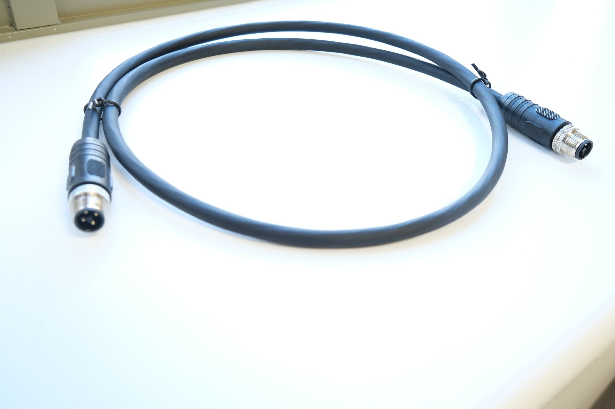 Two cables with connectors on a white surface