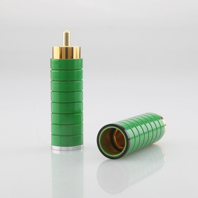 Green RCA connector with gold terminal on a gray background