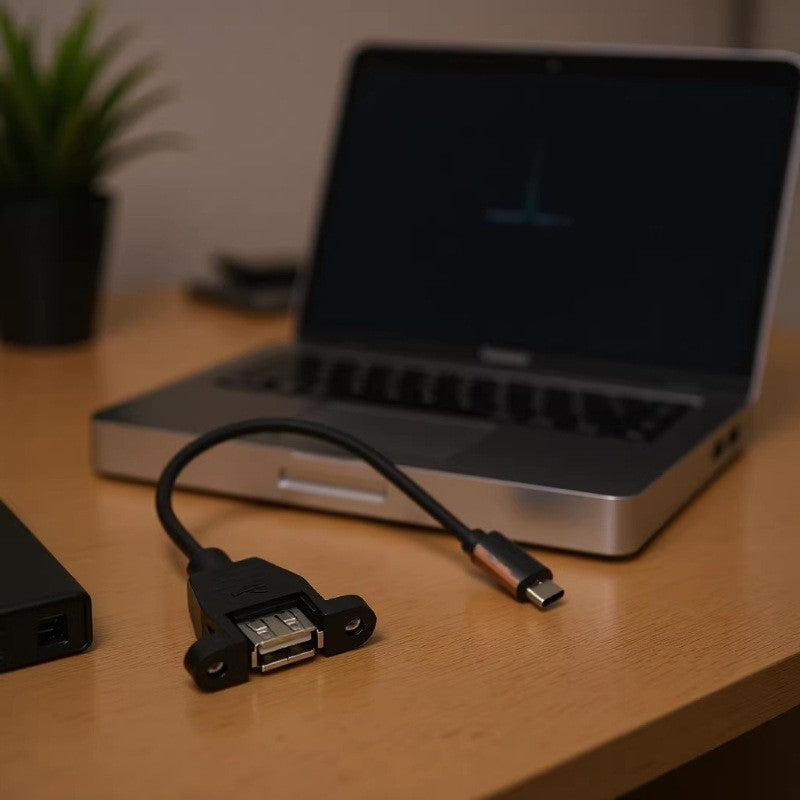 USB extension cable on a desk with a laptop in the background
