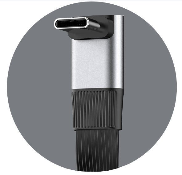 Close-up of a black and silver cylindrical device with a textured grip on a gray background