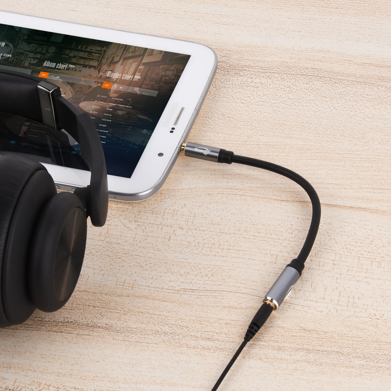 3.5mm TRRS extension cable connected between a smartphone and headset for stereo audio and microphone support